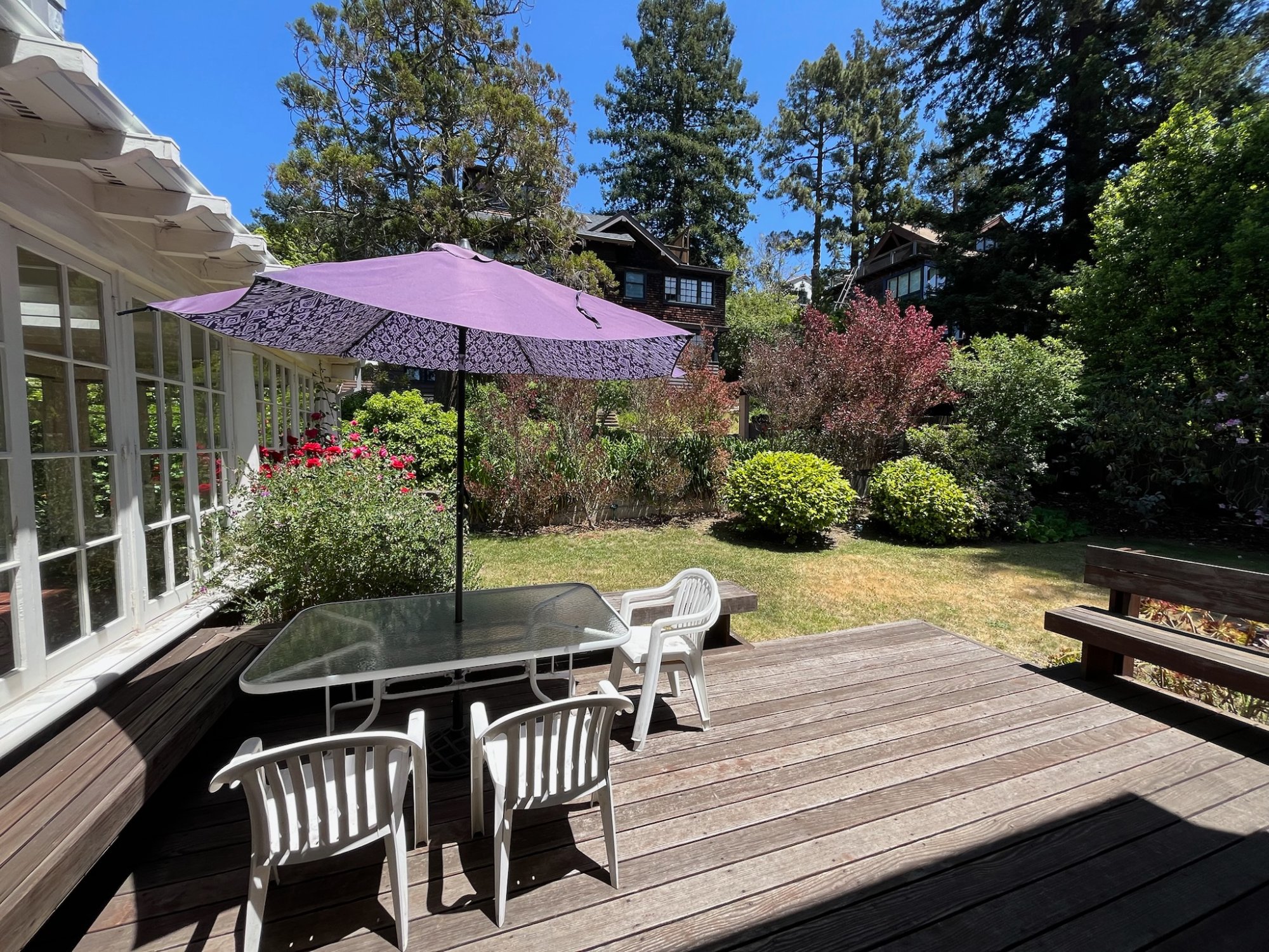 Backyard deck with dining table and lush garden