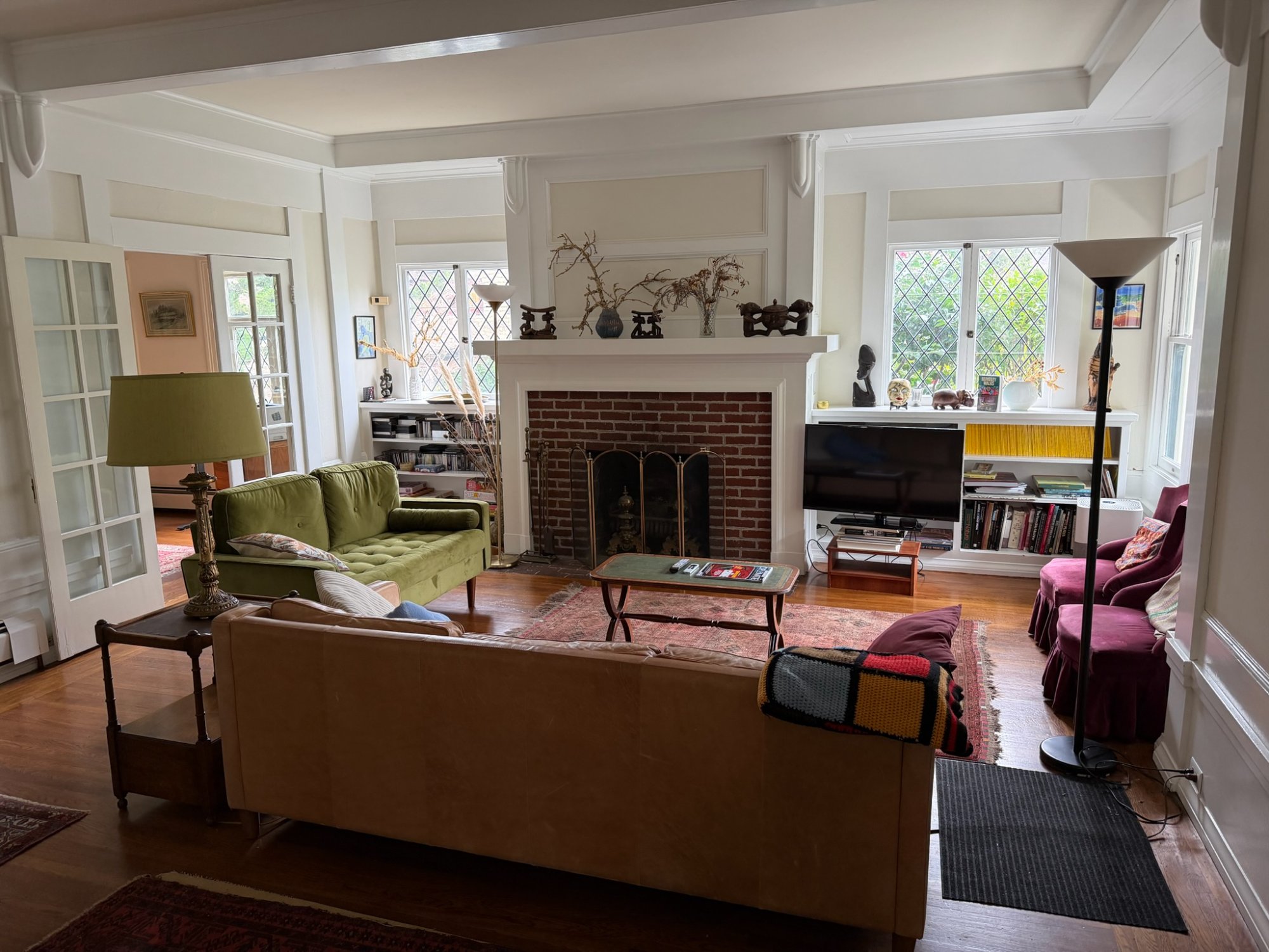 Spacious living room with original brick fireplace and leaded glass windows