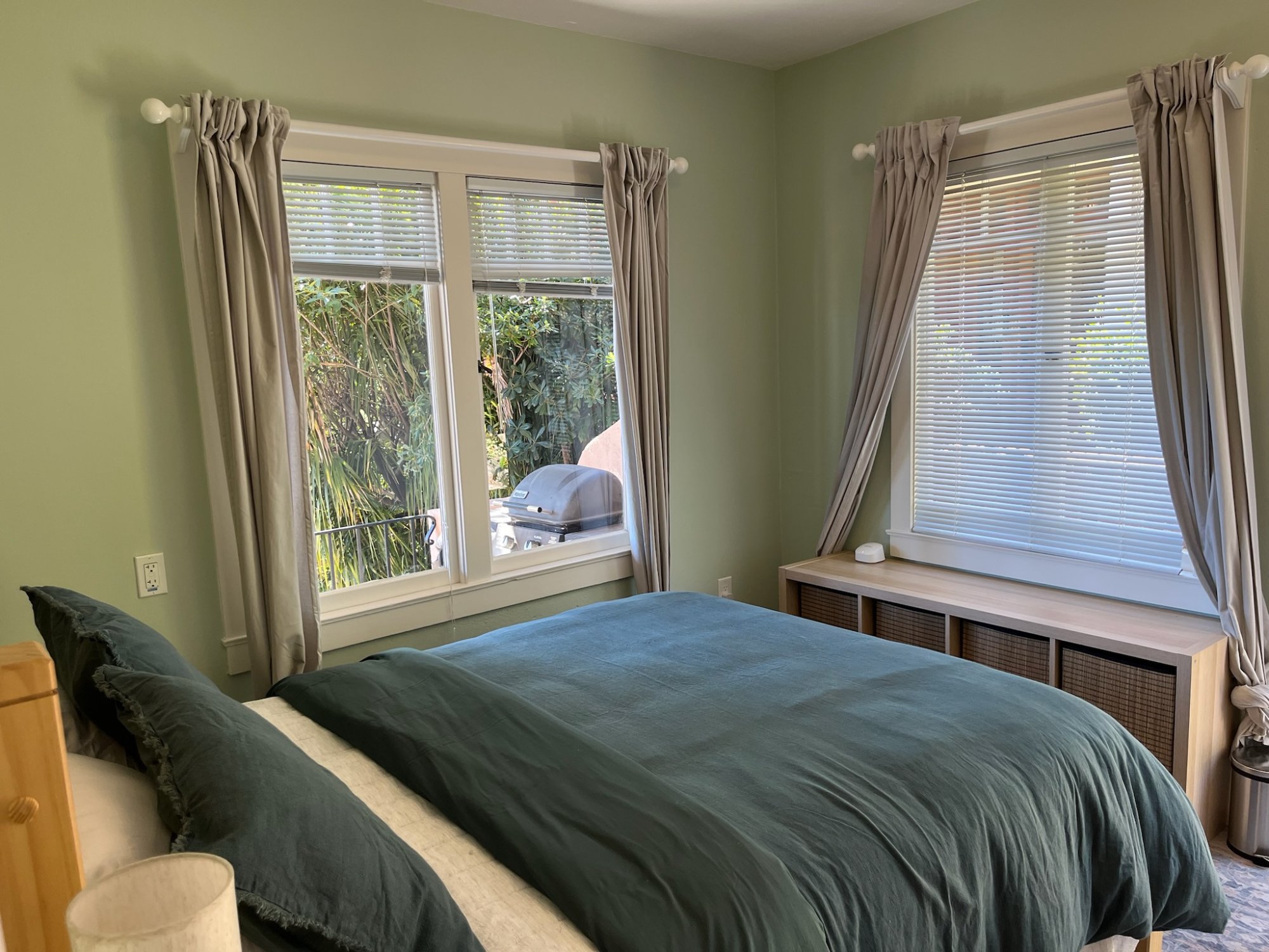 Queen bedroom with bay windows and lush garden outlook