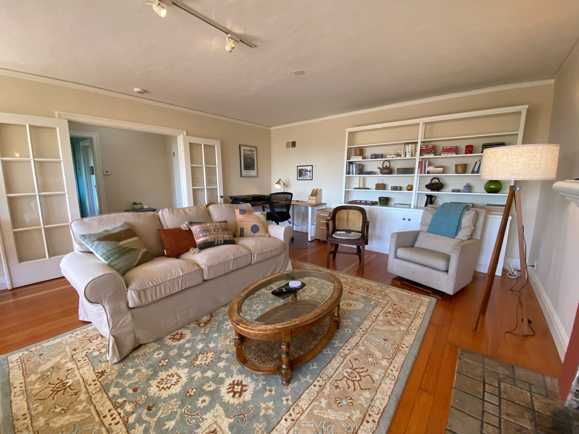 Spacious living room with built-in bookshelves and office workspace