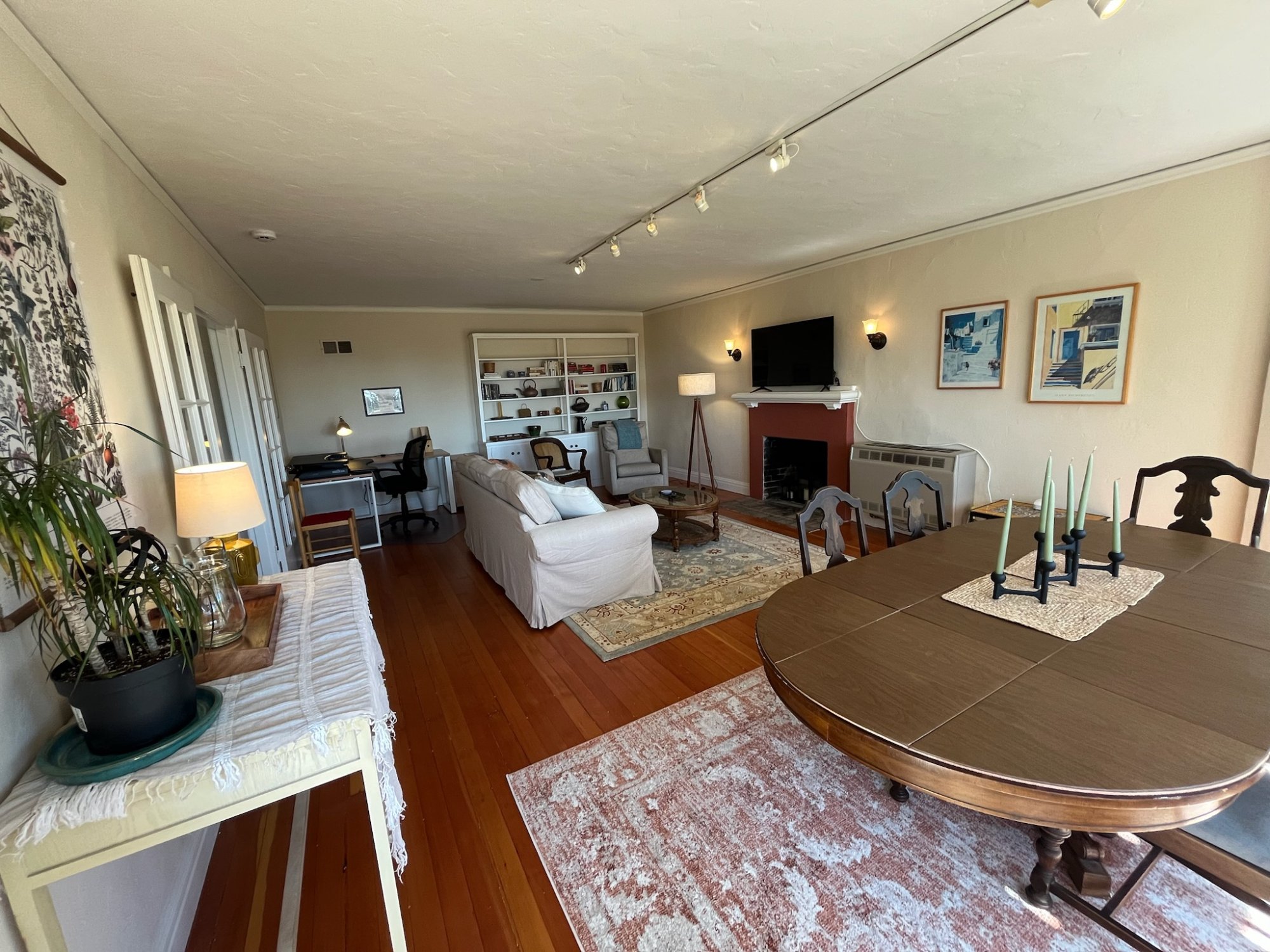 Open living and dining room with hardwood floors and fireplace