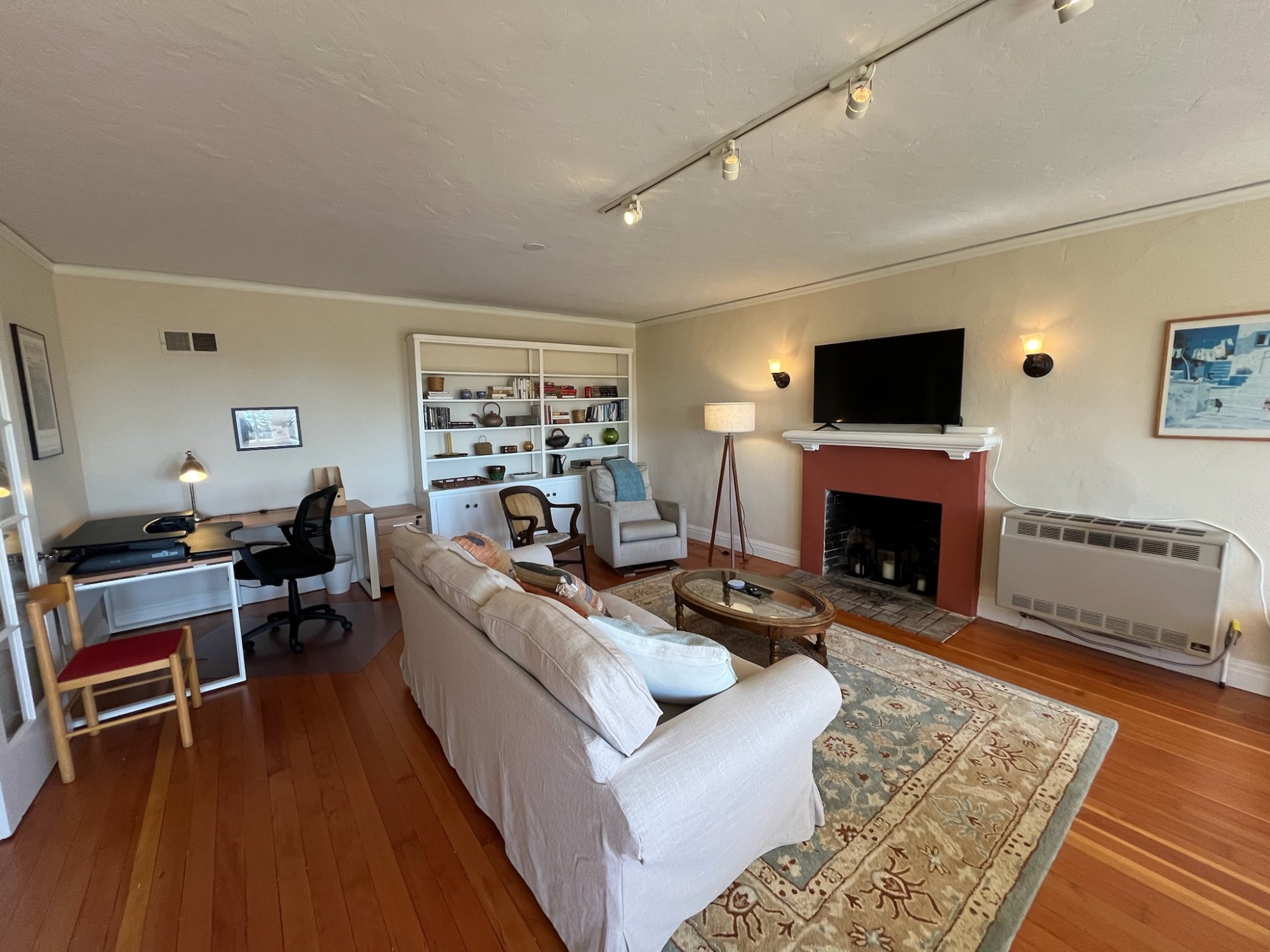 Living room with smart TV, fireplace and sit-stand desk workspace