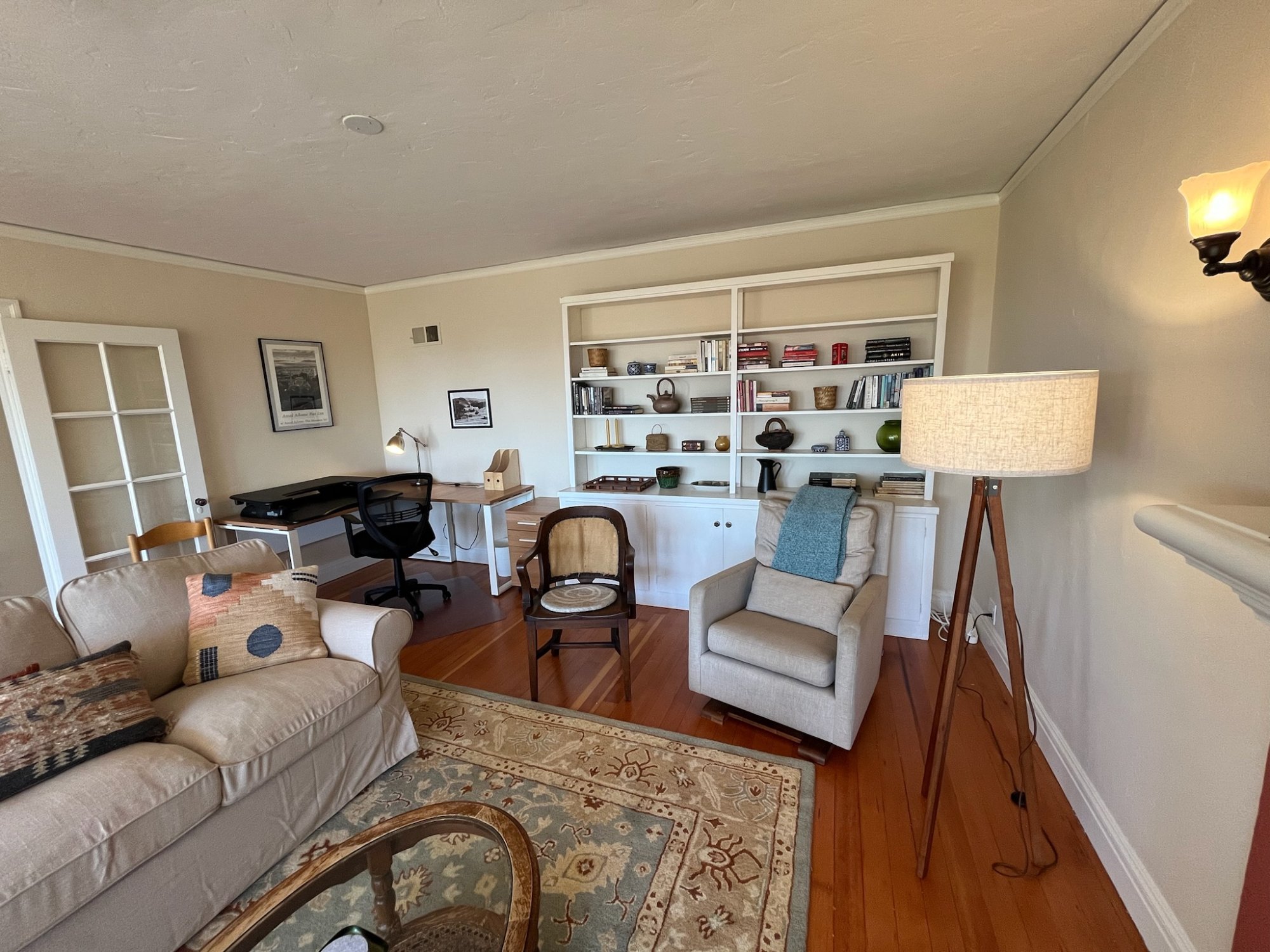 Living room with dedicated office workspace and built-in shelving