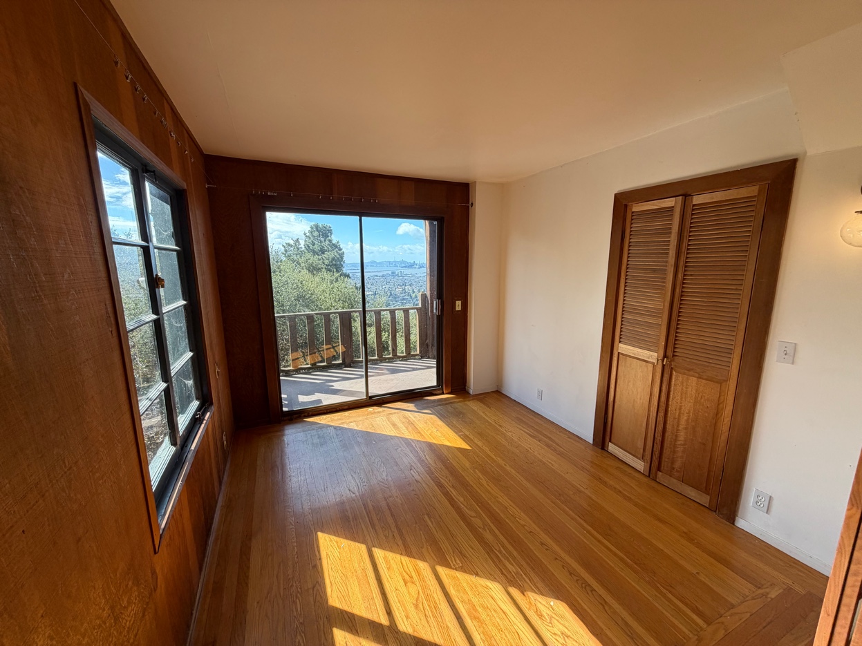 Bright bedroom with sliding door to deck and Bay views