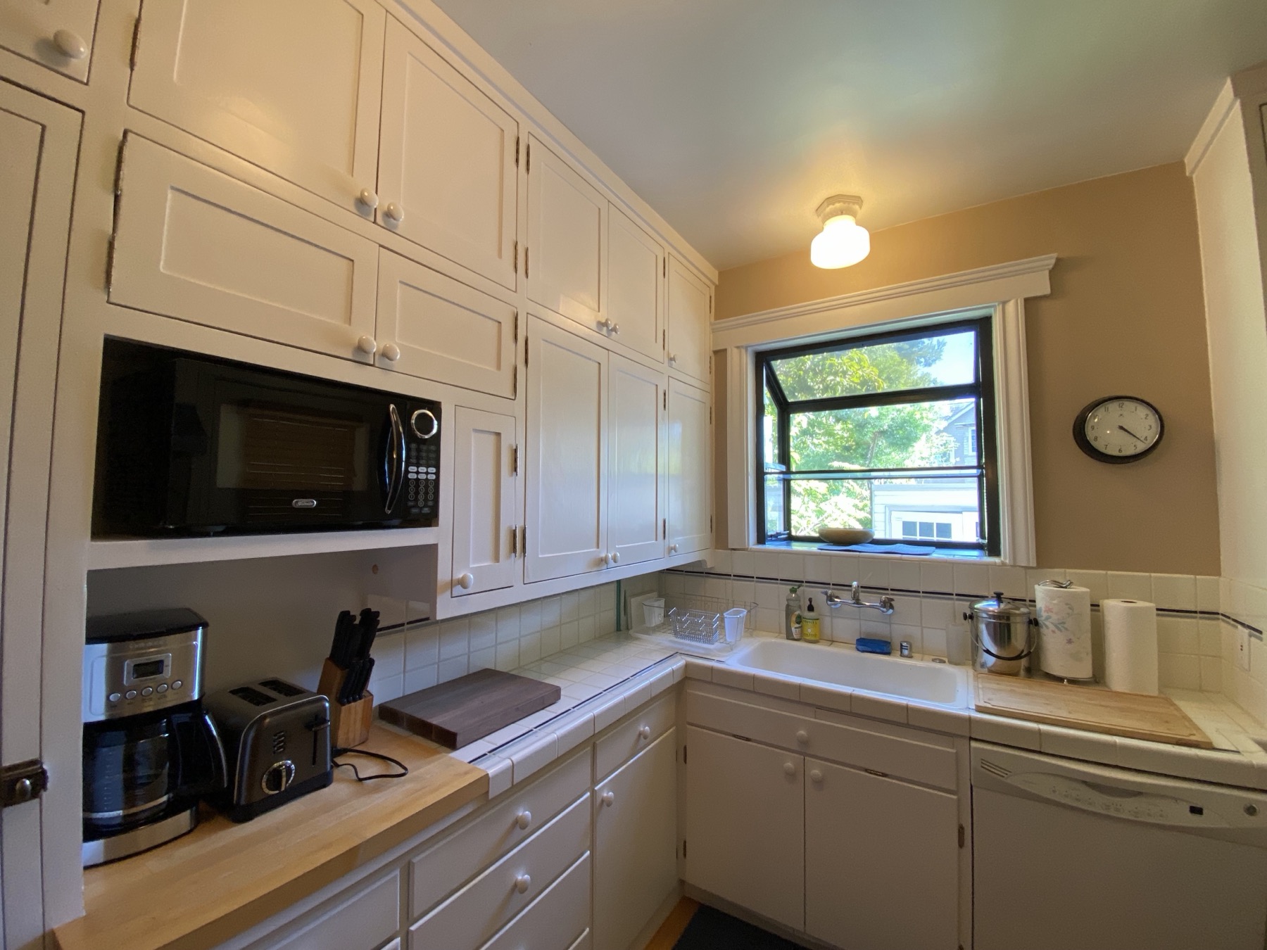 Fully equipped kitchen with white cabinets and gas range