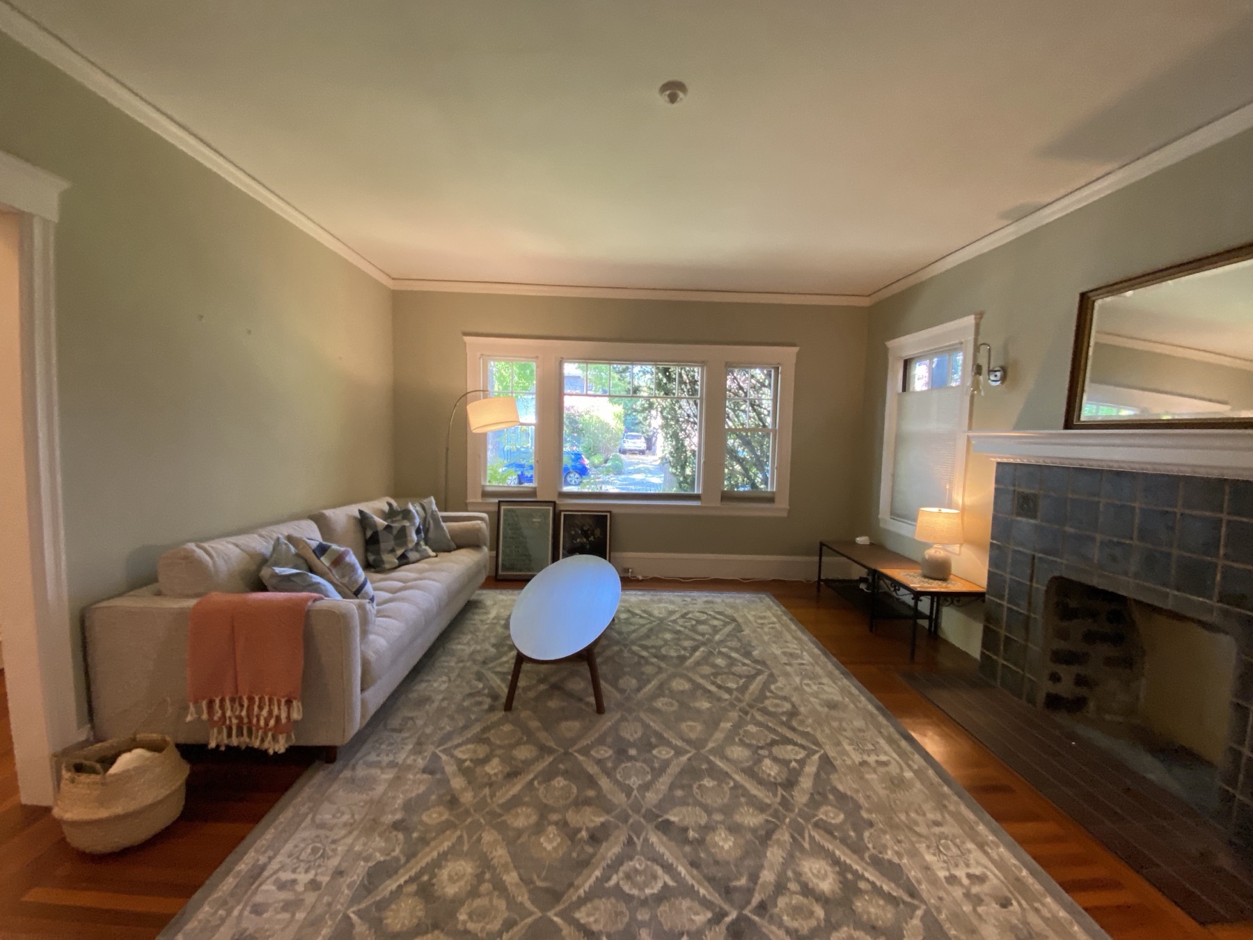 Bright living room with fireplace, large windows, and hardwood floors