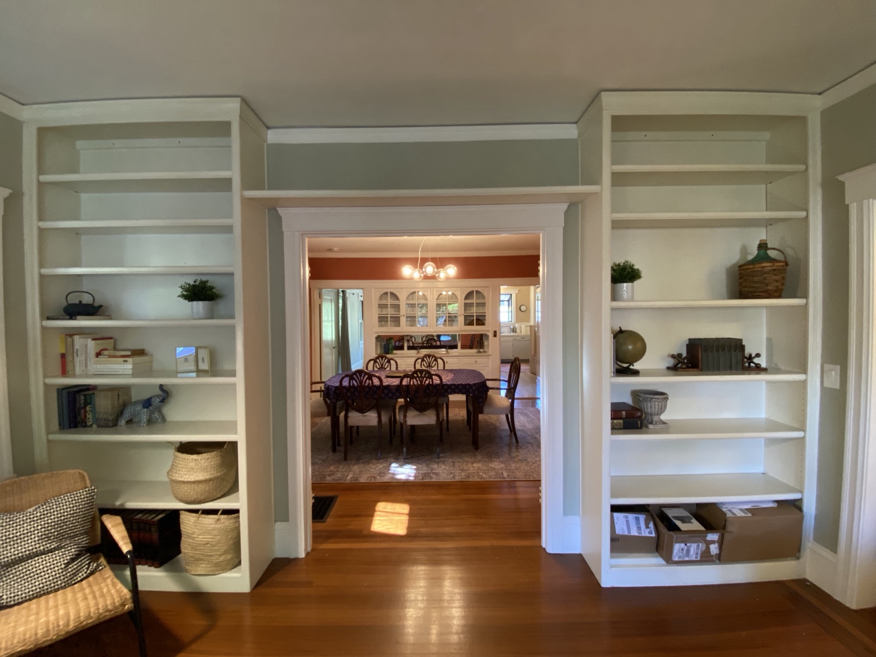 Floor-to-ceiling built-in bookshelves framing view into dining room