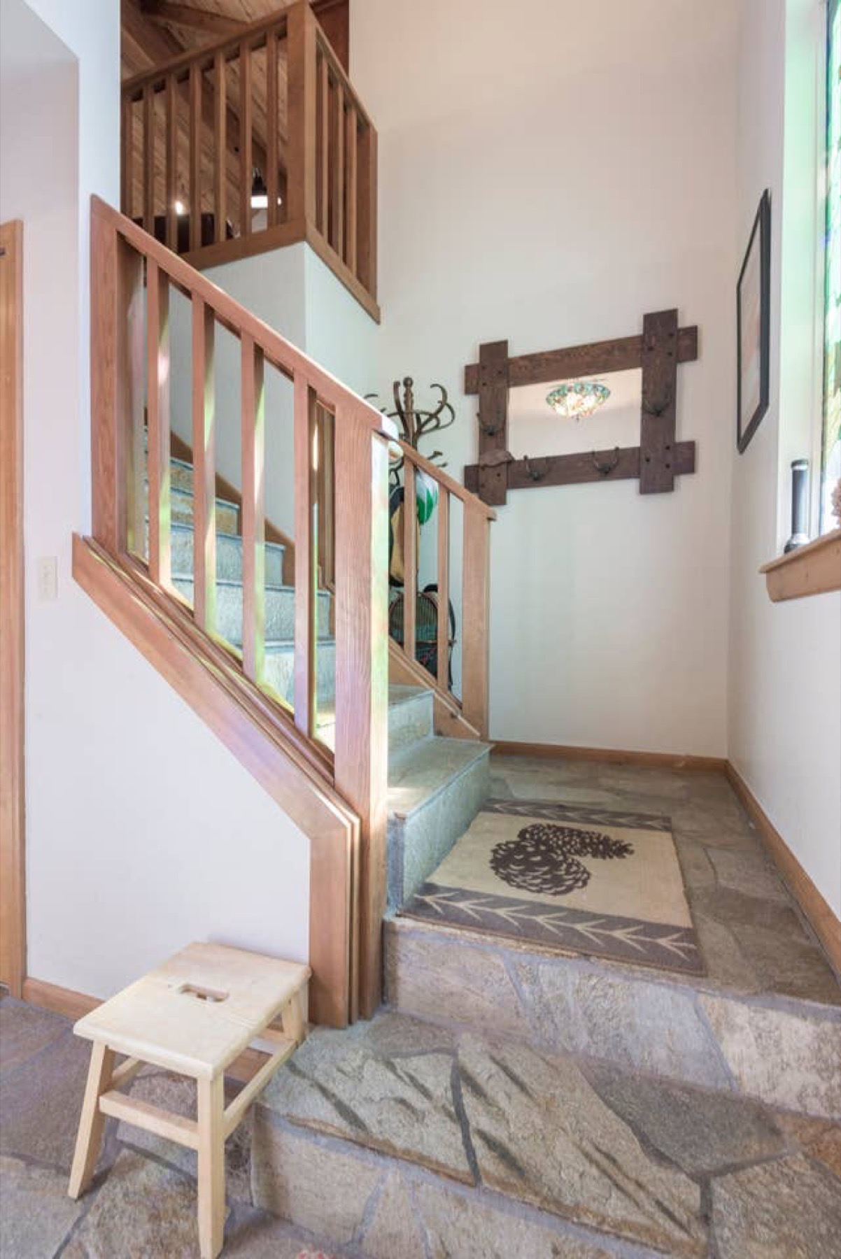 Welcoming wood-railed entryway staircase