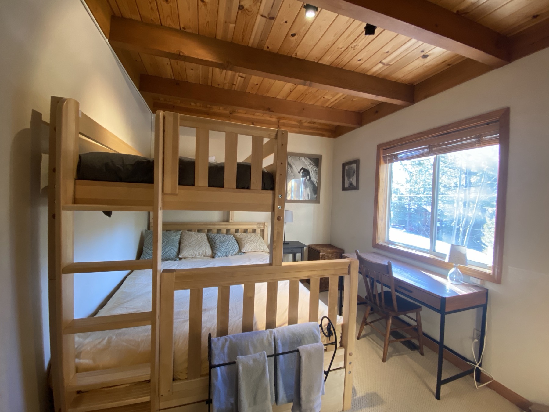Bunk bed bedroom with desk and forest-view window